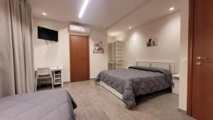 a bedroom with two beds and a desk and a television at Camere Santucci in Assisi