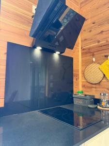 a kitchen with a black counter top with a hood at Le ptit Chalet du bonheur in Entre-Deux