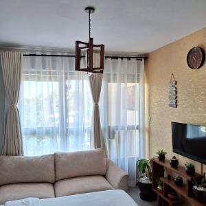 a living room with a couch and a large window at Spacious Studio Apartment with Swimming pool in Nairobi