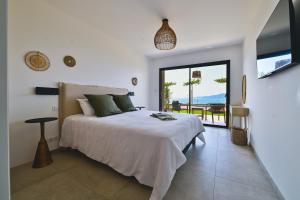 a bedroom with a bed and a view of the ocean at Villa A Pinnata in Albitreccia +70 photos