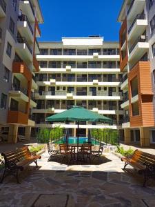 a table with a green umbrella in front of a building at Spacious Studio Apartment with Swimming pool in Nairobi