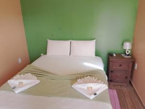 a bedroom with a bed with two pillows on it at Chalé da Pousada Avalon Célia in Alto Paraíso de Goiás