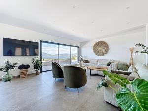 a living room with a couch and chairs and a table at Villa A Pinnata in Albitreccia