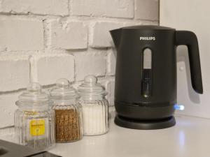 a coffee maker and glass jars of nuts on a counter at Dream Loft in Kłodzko