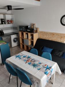 a white table with blue chairs in a living room at La MAISON BLEUE in Calvisson