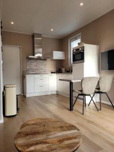 a kitchen with white cabinets and a table and chairs at Vakantiehuis Huisje 31 Zoutelande in Zoutelande +27 photos