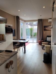 a kitchen and living room with a table and a couch at Vakantiehuis Huisje 31 Zoutelande in Zoutelande