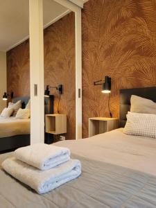 a bedroom with two beds with towels on them at Vakantiehuis Huisje 31 Zoutelande in Zoutelande