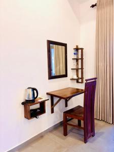 a room with a table and a mirror and a chair at Hotel Siyomin in Ahangama