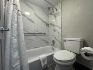 a bathroom with a toilet and a tub and a toilet paper roll at Red Roof Inn Arlington - Entertainment District in Arlington +28 photos