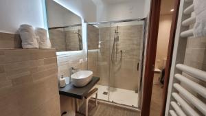 a bathroom with a sink and a glass shower at Camere Santucci in Assisi