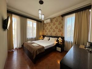 a bedroom with a bed in a room with windows at Four brother in Tbilisi City