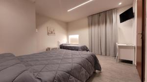 a hotel room with a bed and a television at Camere Santucci in Assisi +14 photos