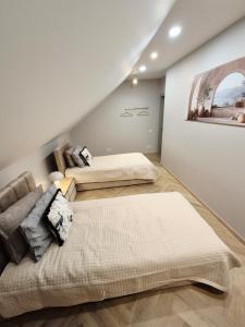 a bedroom with two beds and a painting on the wall at VHausPlunge in Plungė