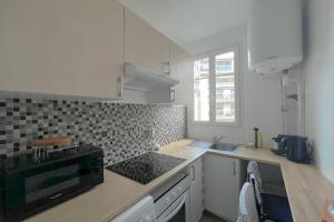 a kitchen with a sink and a stove top oven at Room in elegant 3-bedroom apartment near Bois de Vincennes in Paris
