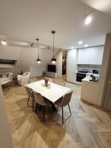 a kitchen and living room with a white table and chairs at VHausPlunge in Plungė