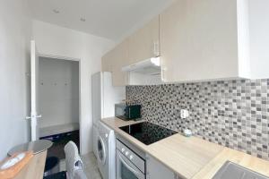 a kitchen with white cabinets and a counter top at Room in elegant 3-bedroom apartment near Bois de Vincennes in Paris