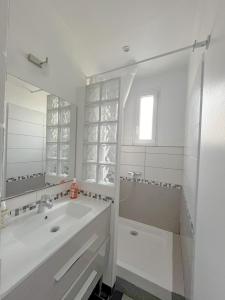 a white bathroom with a sink and a mirror at Room in elegant 3-bedroom apartment near Bois de Vincennes in Paris +26 photos