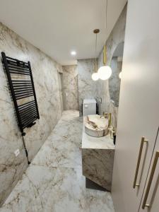 a bathroom with a sink and marble walls at VHausPlunge in Plungė