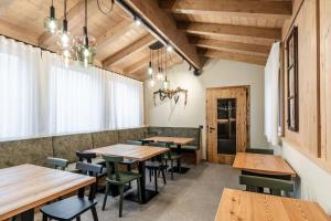 a dining room with wooden tables and chairs at El Giof Alpine Home in Pellizzano