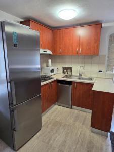 a kitchen with a stainless steel refrigerator and wooden cabinets at House Belavici in Hreljići