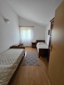 an empty room with two beds and a window at House Belavici in Hreljići