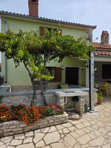 a patio with a table and flowers in front of a house at House Belavici in Hreljići