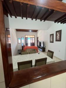 a room with a table and chairs and a bedroom at Casa Fácil in Itacaré