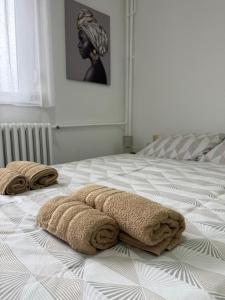two towels are laying on a bed in a bedroom at AG Apartman in Kraljevo