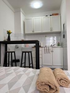 a bedroom with a bed and a kitchen with white cabinets at AG Apartman in Kraljevo