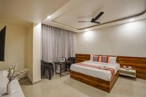 a bedroom with a bed and a table and chairs at Hotel Sayba Inn - Budget Stay! in Pune +9 photos
