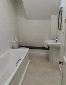 a white bathroom with a tub and a sink at A to B Hotel in London