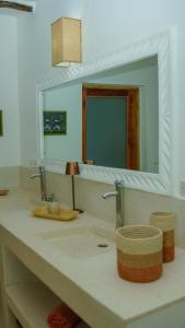 a bathroom counter with a sink and a mirror at Nyumba ya Bubi in Watamu +29 photos