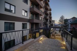 an apartment building with a staircase leading to a balcony at Zlatiborske terase Spa&Wellness in Zlatibor