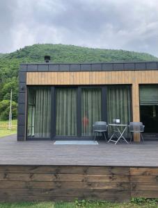 a building with a deck with two chairs and a table at Paporoti House in Korostov