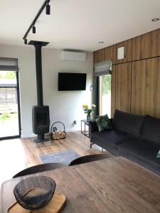 a living room with a black couch and a fireplace at Paporoti House in Korostov