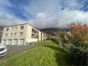 a white building with a hill in the background at Fli Apartment in Weesen