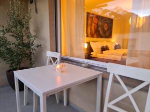 a white table and chair in a room with a bed at Fli Apartment in Weesen
