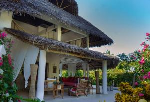 a resort with a patio with chairs and tables at Nyumba ya Bubi in Watamu