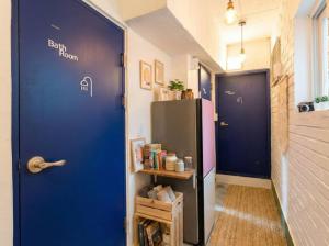 a hallway with a blue door and a refrigerator at 자자쿨스테이 in Seoul +74 photos