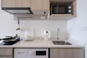 a kitchen with a sink and a microwave at The Hampton Suites Bangna in Bangna