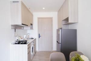 a kitchen with a refrigerator and a table and chairs at The Hampton Suites Bangna in Bangna