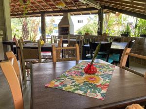 a wooden table with a vase on top of it at Pousada Vale da Praia in Praia do Rosa