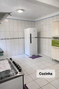a kitchen with a white refrigerator in a room at Pouso Ravenala - Refúgio do viajante in Paraty +20 photos