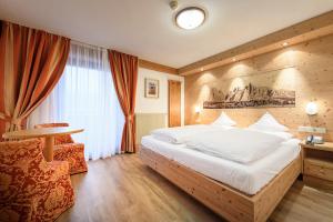 una camera d'albergo con un letto e una finestra di Hotel Ronce a Ortisei