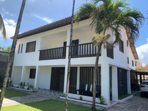 a house with palm trees in front of it at A passos do paraíso!! in Lauro de Freitas