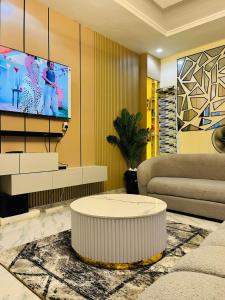 a living room with a couch and a tv at OS Dominion Homes in Mama +15 photos