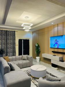 a living room with a couch and a tv at OS Dominion Homes in Mama