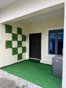 a room with green plants on the side of a house at OS Dominion Homes in Mama