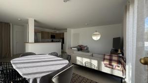 a living room with a table and a kitchen at La villa caroline in Léon